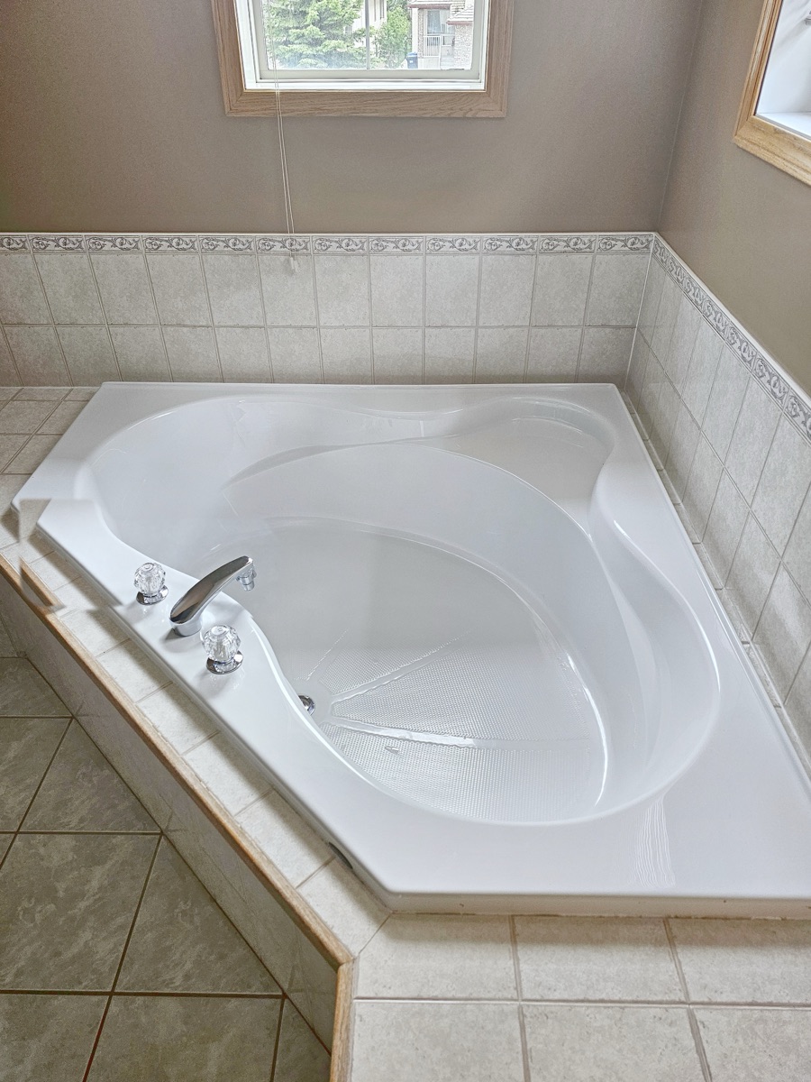Corner soaker tub gleaming with a clean tile surround after a NeatNow first time clean in Calgary