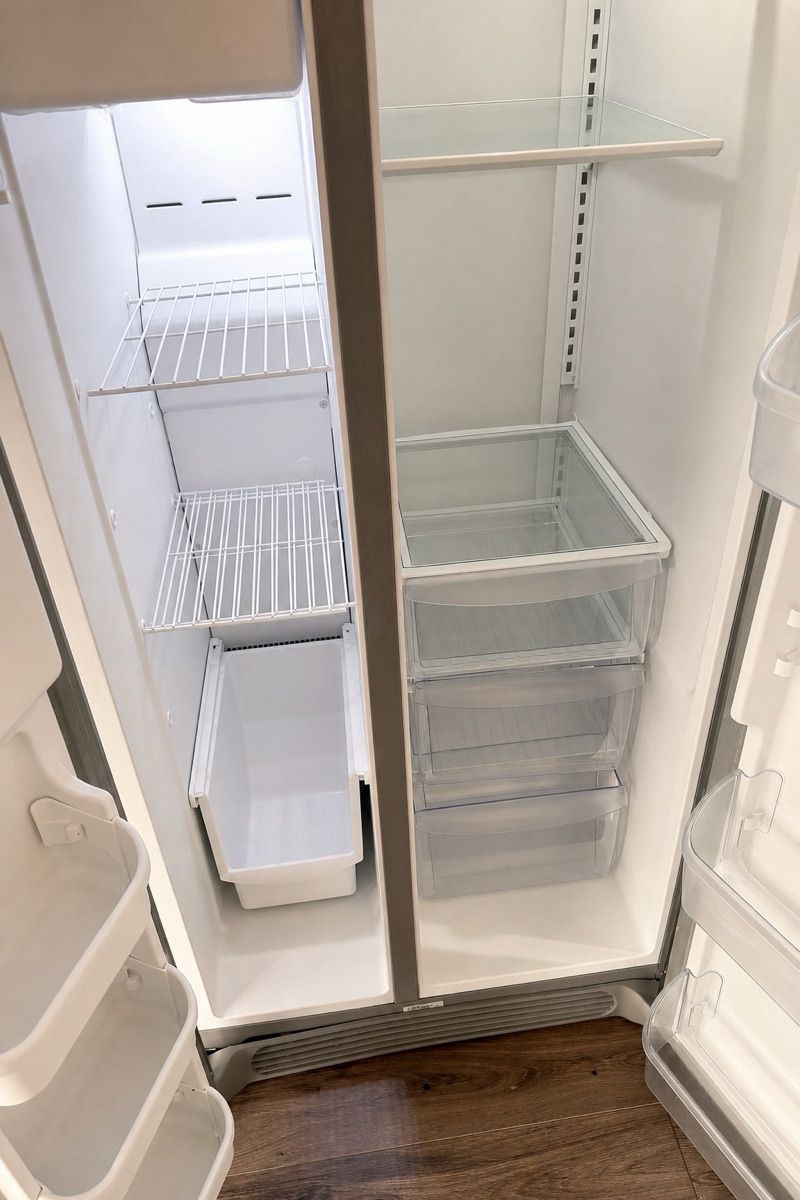 Empty fridge interior with spotless shelves and drawers after a NeatNow move-out clean