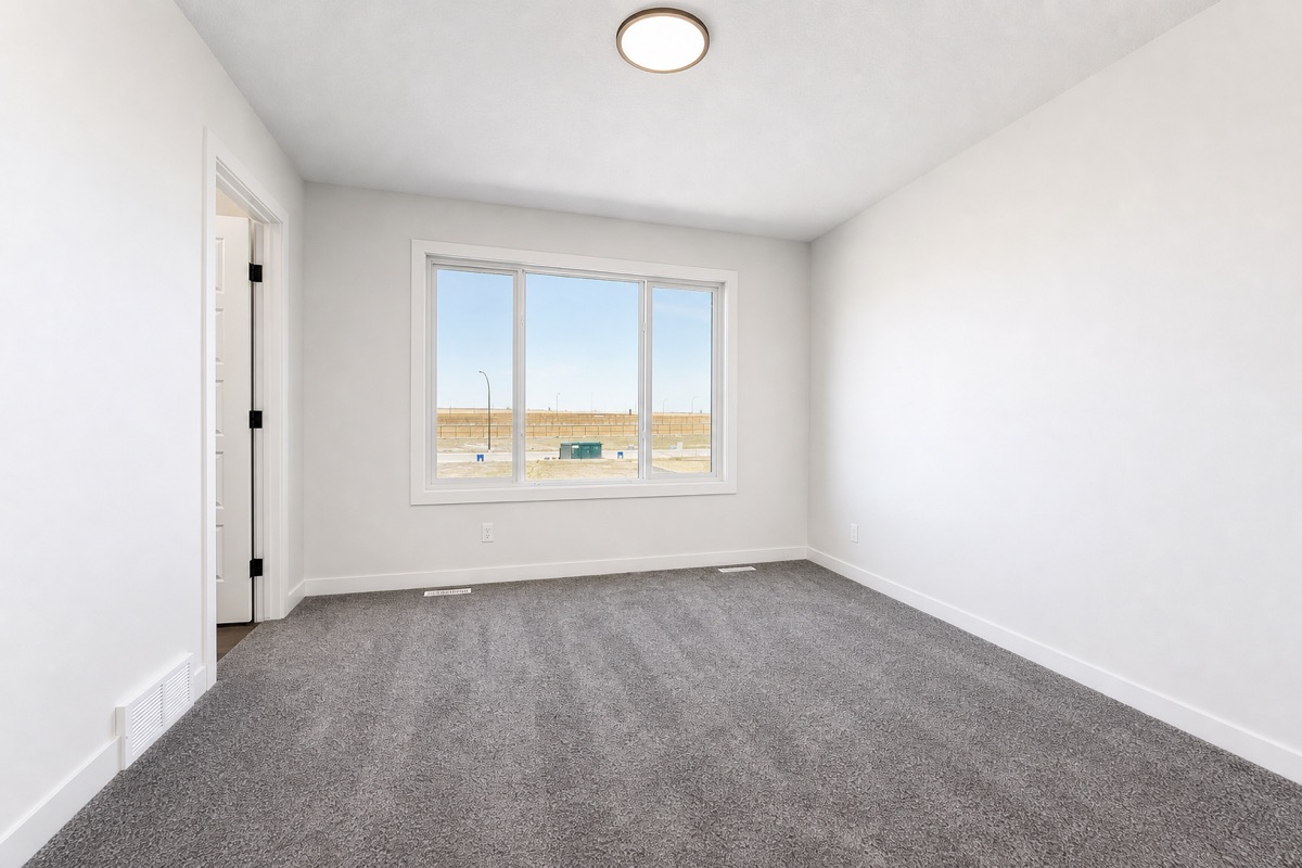 Bedroom with freshly vacuumed carpet and bright window after a NeatNow clean