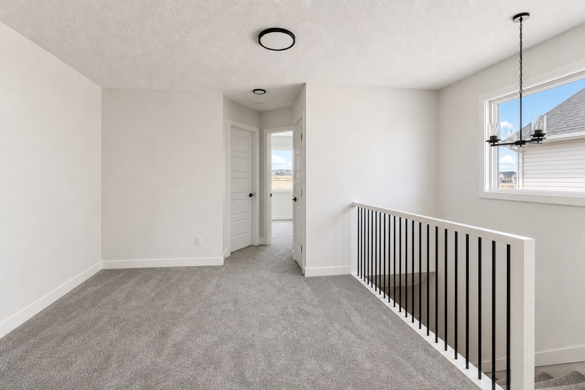 Bright upper-floor bonus room with fresh carpet and black spindle railing after a NeatNow clean