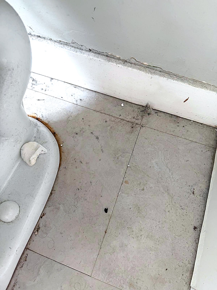 Before photo of a bathroom tile floor with built-up grime along the grout, before a NeatNow clean in Calgary