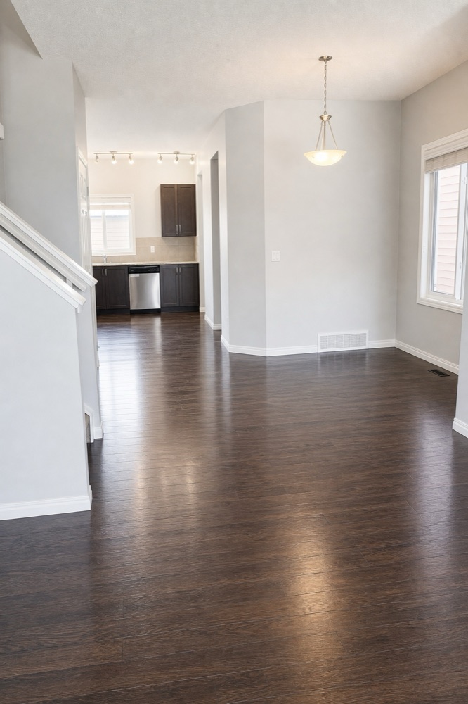 Open-concept living space with dark hardwood floors cleaned for a move-out in Calgary