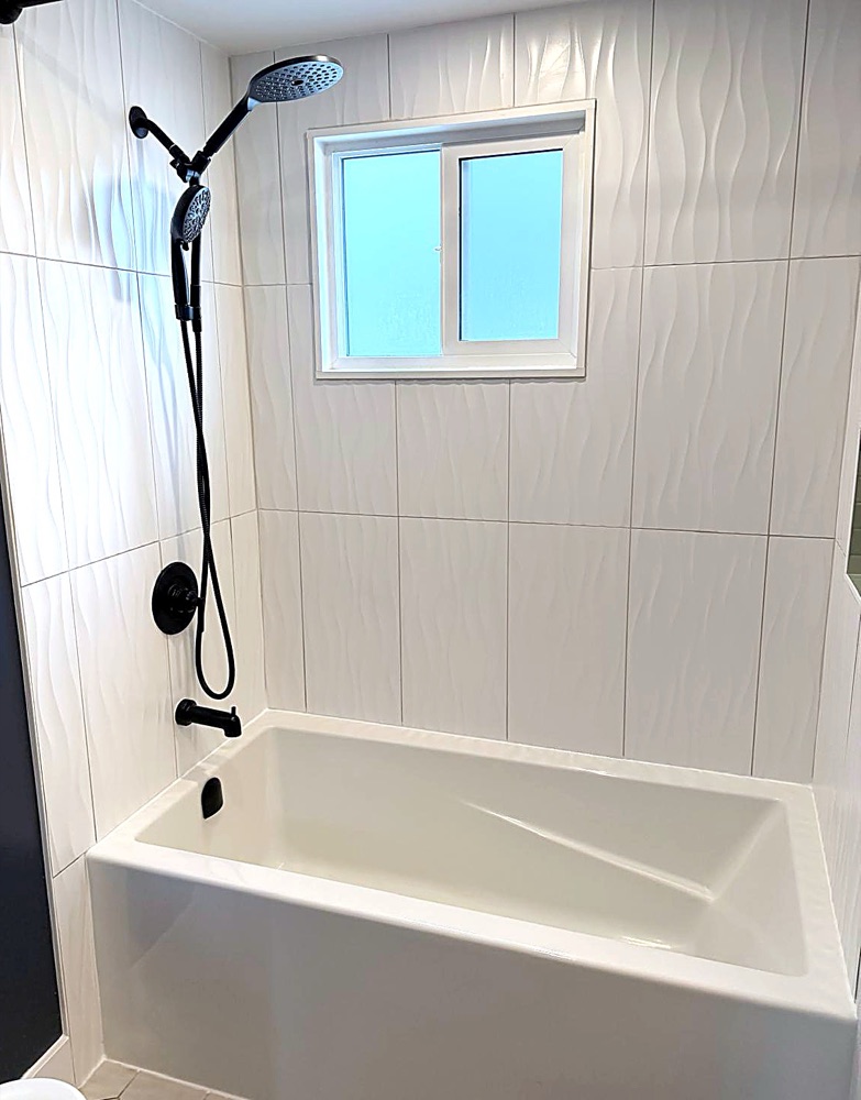 Finished tub and tiled shower with black fixtures after a NeatNow clean in Calgary