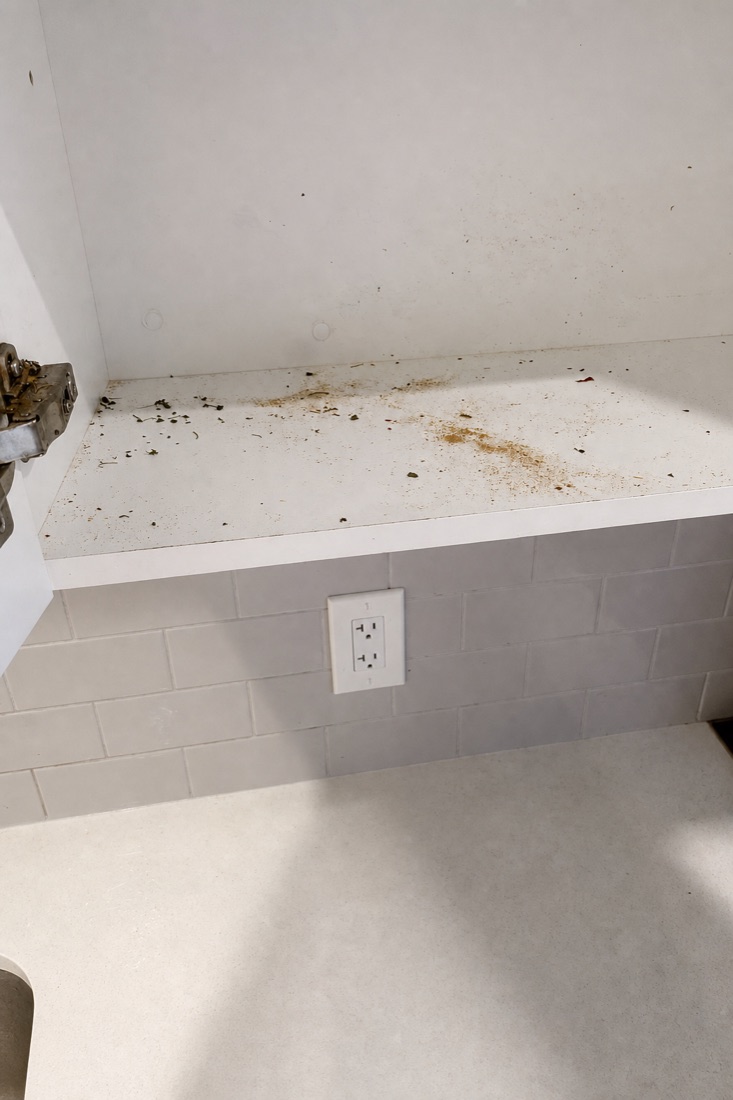 Before photo of a shelf with crumbs, dust, and rings, before a NeatNow clean